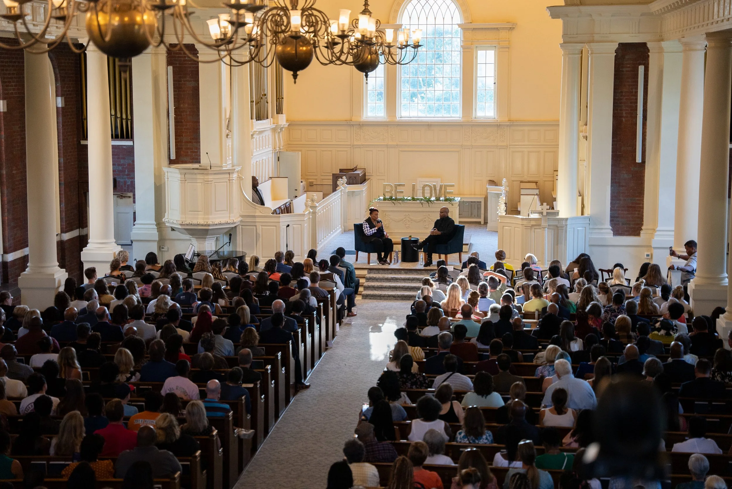 Large audience gathered in a hall for a live event